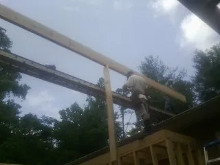 Carpenter setting a ridge beam over a new addition frame — Ice Dam Removal by Roofing Brothers in Staffordsville