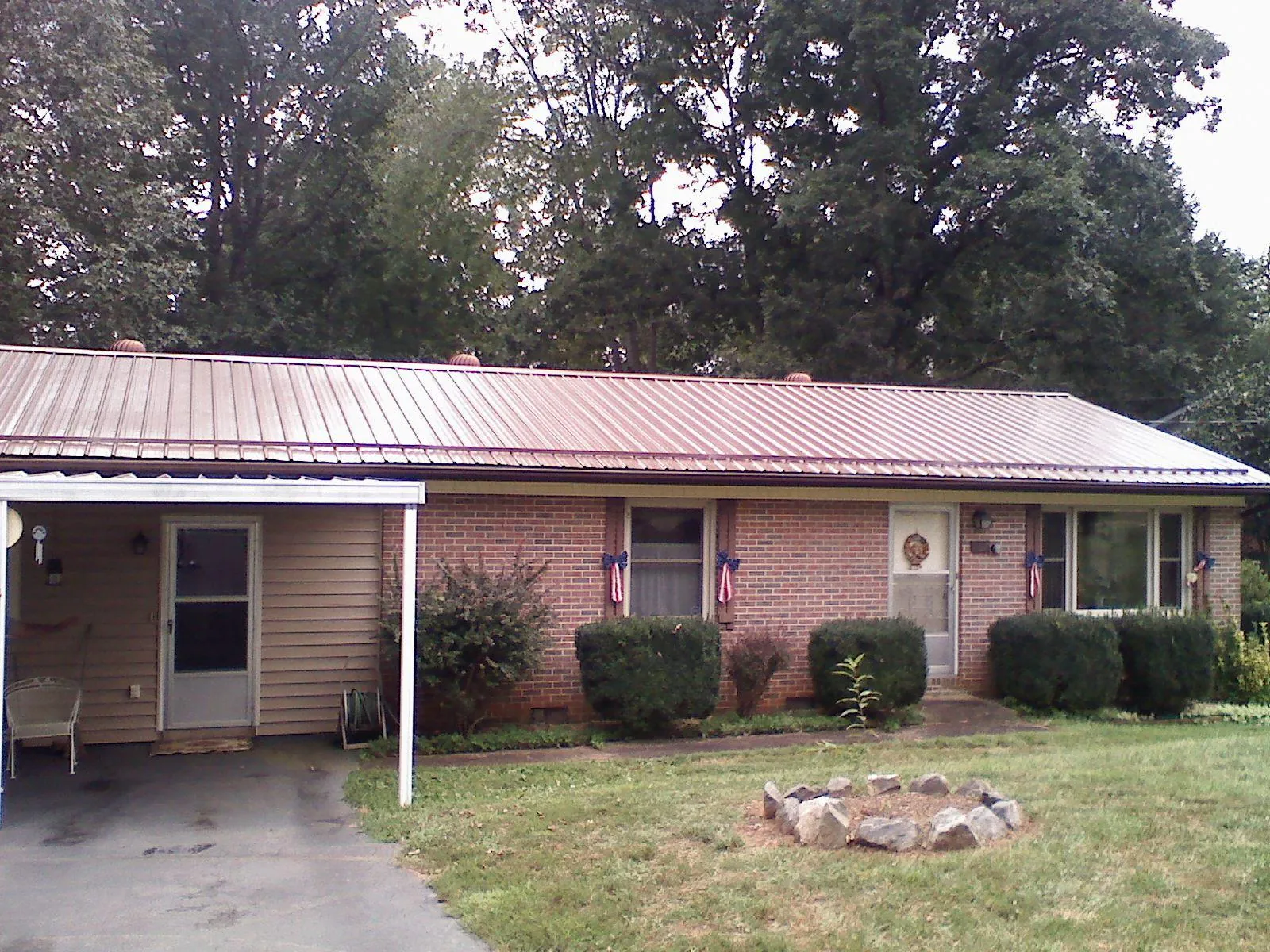 Bronze metal roof and carport on a brick ranch home — Roof Repair work by our crew in Staffordsville